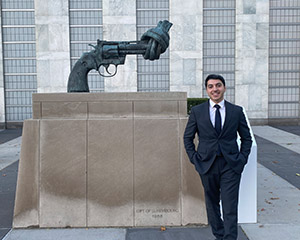 Almuntaser Albalawi in front of statue of pistol with knotted barrel