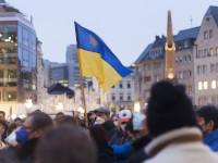 Ein Mann schwenkt Flagge der Ukraine auf einer Demonstration