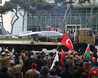Ein unbemanntes Luftfahrzeug des Typs Heron-1 MK II mit mittlerer Flughöhe und langer Lebensdauer (MALE), hergestellt von Israel Aircraft Industries, nimmt an einer Militärparade in Baku, Aserbaidschan, teil. Zu sehen ist eine Menschenmenge mit aserbaidschanischen und türkischen Flaggen.