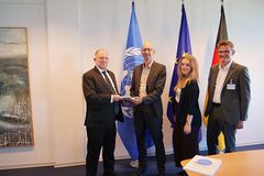 Tobias Debiel und Conrad Schetter übergeben das Friedensgutachten an Mitarbeitende des BMZ