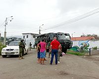 Zivipersonen und Militär mit Fahrzeugen auf einer Straße
