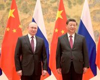 Vladimir Putin und Xi Jinping vor den chinesischen und russischen Länderflaggen.